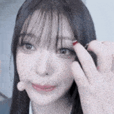 a close up of a woman 's face with a red nail polish