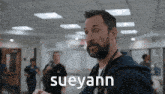 a man with a stethoscope around his neck says sueyann in a hospital
