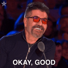 a man wearing glasses and a black jacket says okay good