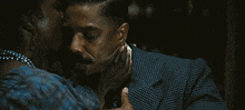 a man in a suit is being kissed by a woman