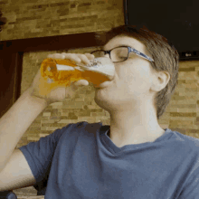 a man wearing glasses is drinking from a glass of beer
