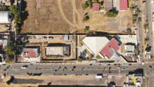 an aerial view of a residential area with a few buildings in the background