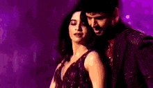 a man and a woman are dancing on a stage in front of a bouquet of flowers .