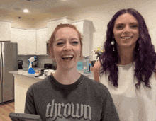 a woman wearing a shirt that says thrown laughs in a kitchen