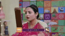 a woman in a pink saree is looking at herself in a mirror with a sony logo in the corner
