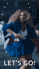 a woman in a blue skirt is dancing with the words `` let 's go '' behind her .