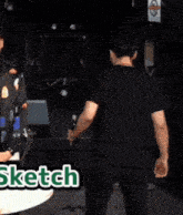 a man in a black shirt is holding a bottle of beer in front of a sign that says sketch