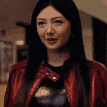 a woman wearing a red leather jacket and a black shirt