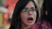 a woman wearing glasses makes a surprised face