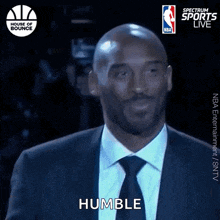 a man in a suit and tie says humble in front of a house of bounce logo