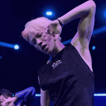 a man with white hair is wearing a black tank top that says infinite on it