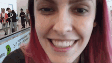 a girl with pink hair is smiling in front of a sign that says enjoy the journey