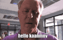 an older man says hello kaanmnv in a purple shirt