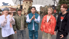 a group of young men standing next to each other with a stop sign in the background