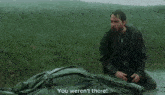 a man is kneeling in the rain with the words " you weren 't there " on the bottom