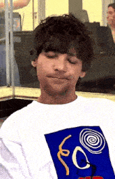 a man wearing a white t-shirt with a blue swirl on it