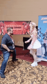a woman in a pink dress is dancing in front of a sign that says jenni cos