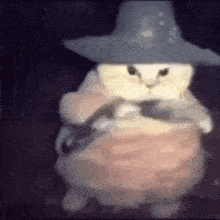 a cat wearing a witch hat and a dress is holding a mouse .