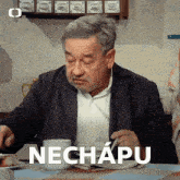 a man sitting at a table with a cup of coffee and the word nechapu written on the bottom
