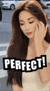 a woman with long hair is standing in front of a sign that says " perfect "