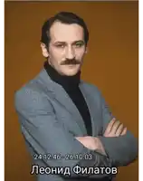 a man with a mustache is wearing a suit and a black turtleneck with the date 24.12.26-26.10.03