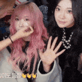 a woman with pink hair is getting her makeup applied
