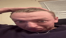 a man with his hand on his head is making a funny face