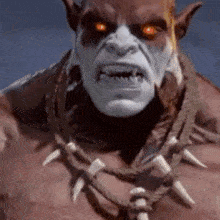 a close up of a monster with glowing red eyes and a necklace around his neck .