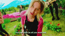 a woman in a pink shirt says " you can hate us all you want but " in front of a group of people