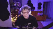 a man wearing glasses and a black shirt that says ft on it