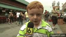 a young boy is holding a microphone that says 16 on it
