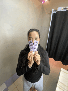 a woman holds up a row of purple cards