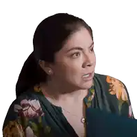 a woman wearing a floral shirt and a silver necklace looks angry
