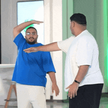 a man in a blue shirt is being measured by another man
