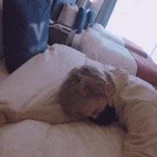 a person is laying on a bed with a bag that says v on it