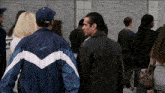 a man wearing a nike jacket is walking in a crowd