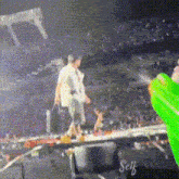 a person is walking on a stage with a green water gun in the foreground