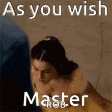 a woman in a yellow dress is standing next to a man in a blue shirt and says `` as you wish master rob '' .