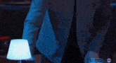 a man with long hair and a beard is standing in a dark room with red lights behind him .
