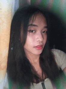 a girl with long black hair is standing in front of a window