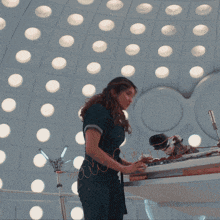 a woman standing in front of a ceiling with lots of lights