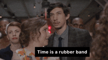 a man in a suit and tie stands next to a woman with the words time is a rubber band written below him