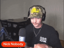 a man wearing headphones and a hat is talking into a microphone with the name nick nobody above him