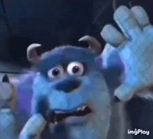 a close up of sulley from monsters inc making a scary face .