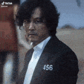 a man in a suit with the number 456 on his chest .