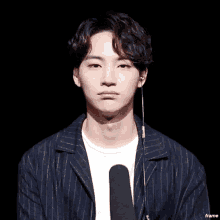 a young man is making a funny face with his hands while wearing headphones .