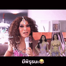 a woman with curly hair is holding a microphone in front of a picture of a woman