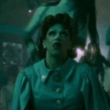 a woman in a blue dress is standing in front of a statue .