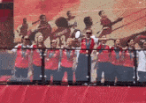 a group of people standing in front of a wall with campbell on the back of their jersey
