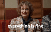 a woman in a plaid jacket is smiling with the words everything is fine below her